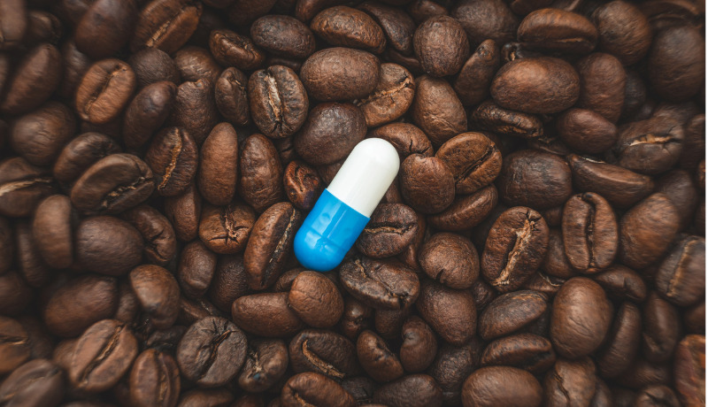 Blue and white capsule on coffee beans